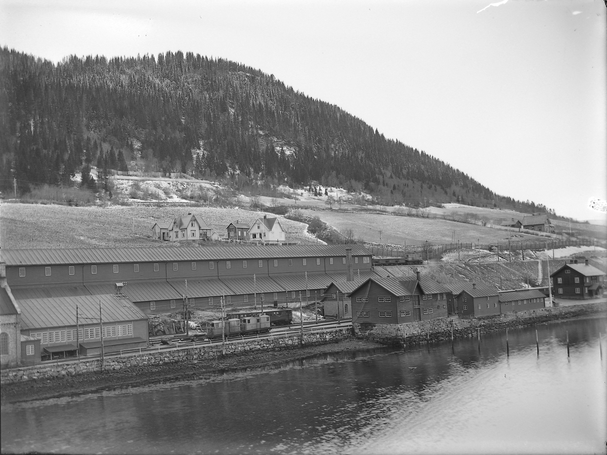 Thamshavn stasjon med kislager, jernbaneverksted og kai. Boliger i bakgrunnen.