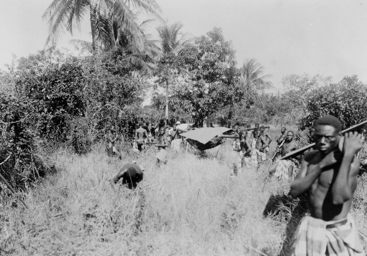 Mosambik. 1914. Fra en tur ut i bushen. Afrikanere bærer europeere i bærestoler kalt machila.