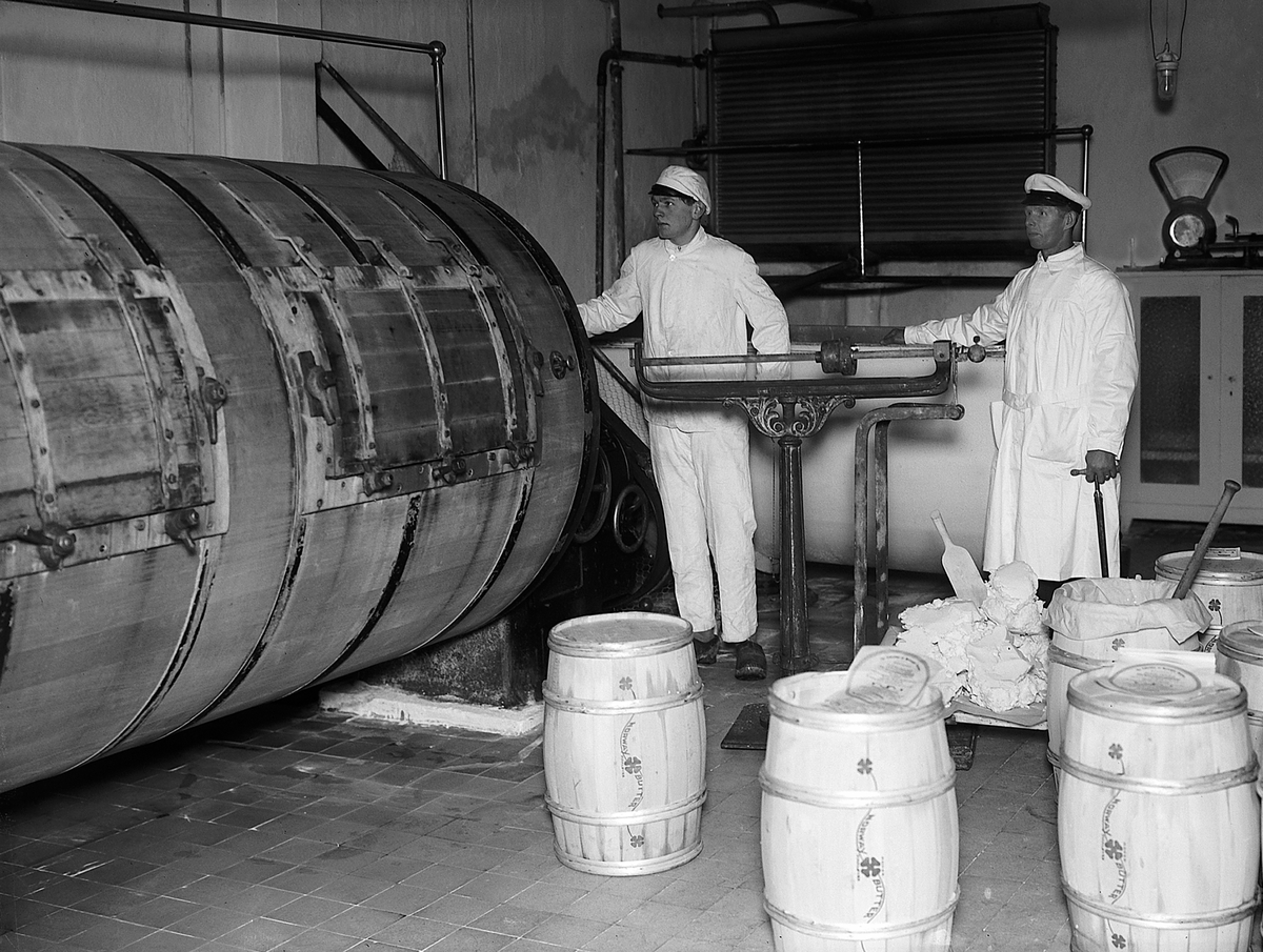 Løten Meieri, interiør, to ukjente menn, smørvekt, smørproduksjon. Tønner av tre "Norway Butter"