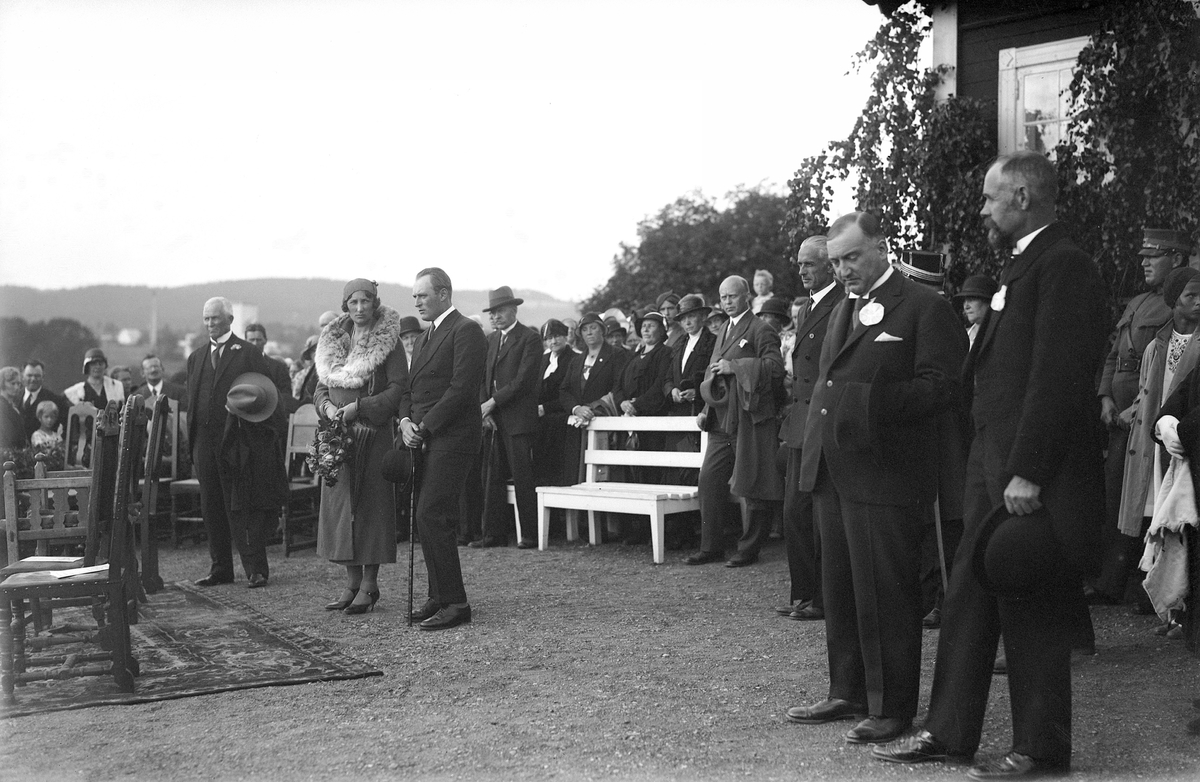 Hamar, Domkirkeodden, kronprinsparet deltar på olsokstevnet 1932, mottagelse for kronprins Olav og kronprinsesse Märtha, stående fra høyre: Grill Fasting (med skjegg), Büring Dehli, adjutant Nikolai Ramm Østgaard, O. Østby Deglum (med kappe over armen), Oline Holtmoen, fru Østby Deglum, mann mad hatt i handa t.v. fylkesmann Knud Øye, den gamle kafeen på museet t.h.