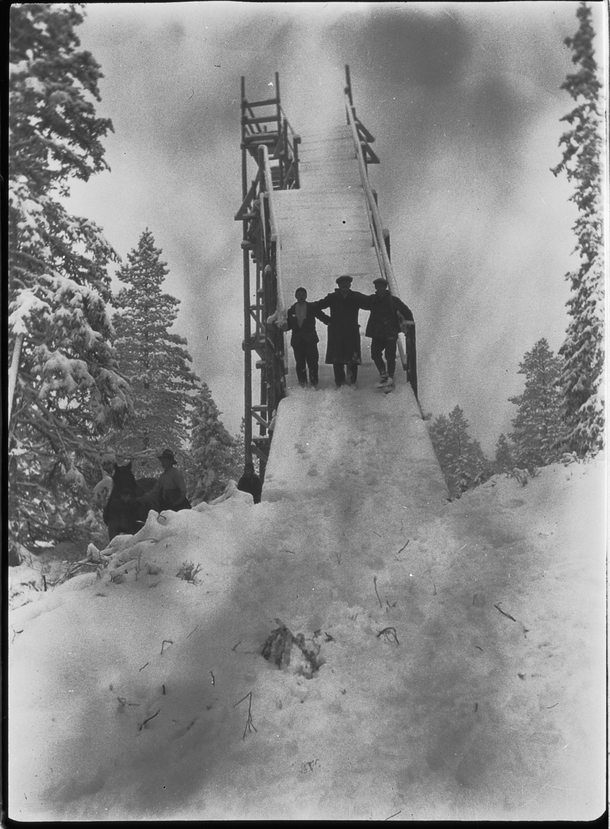 Tre menn på en ukjent skihoppbakke, stillas,