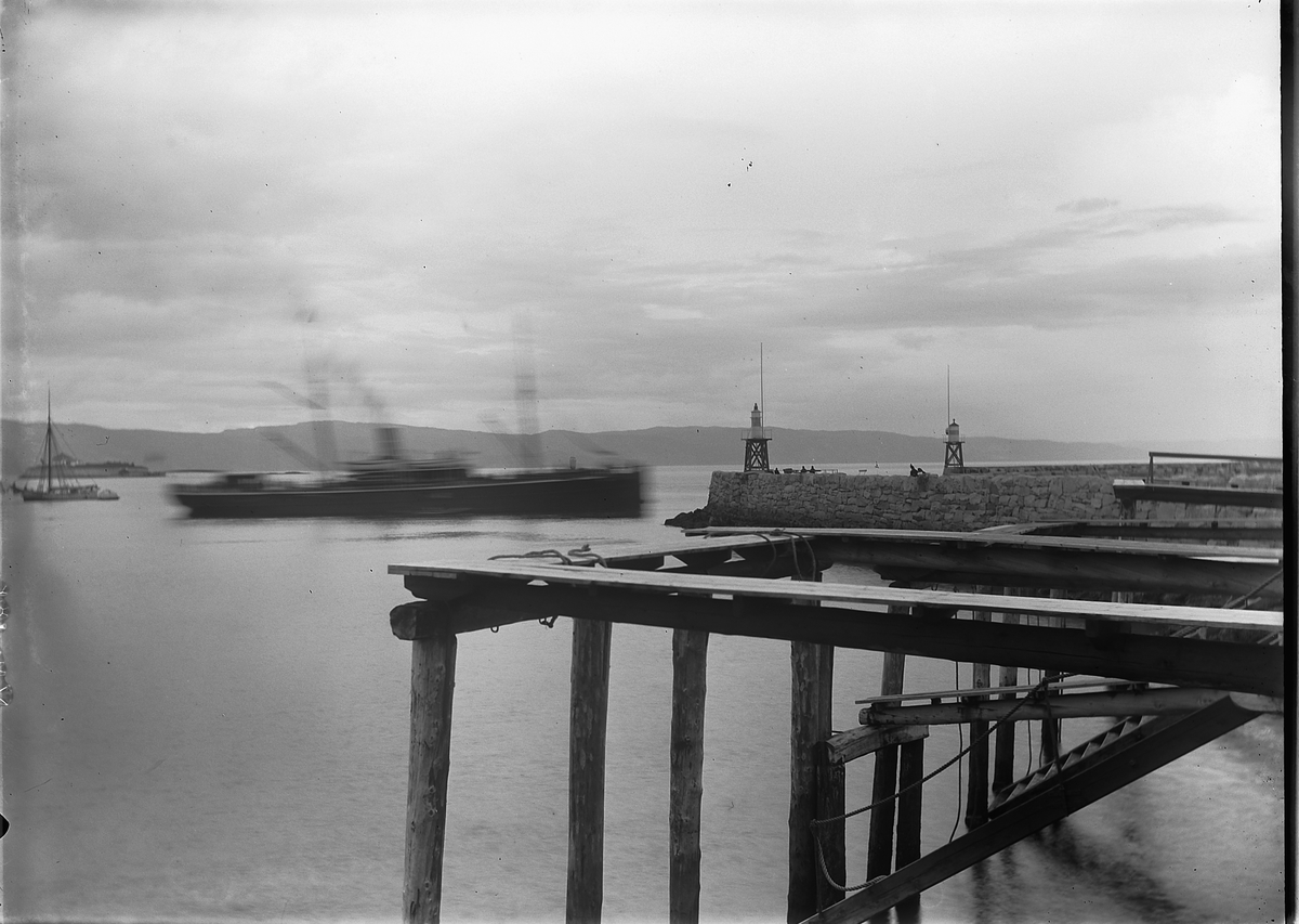 Båt passerer moloen i Trondheim. Munkholmen sees i bakgrunnen. Dampskip.