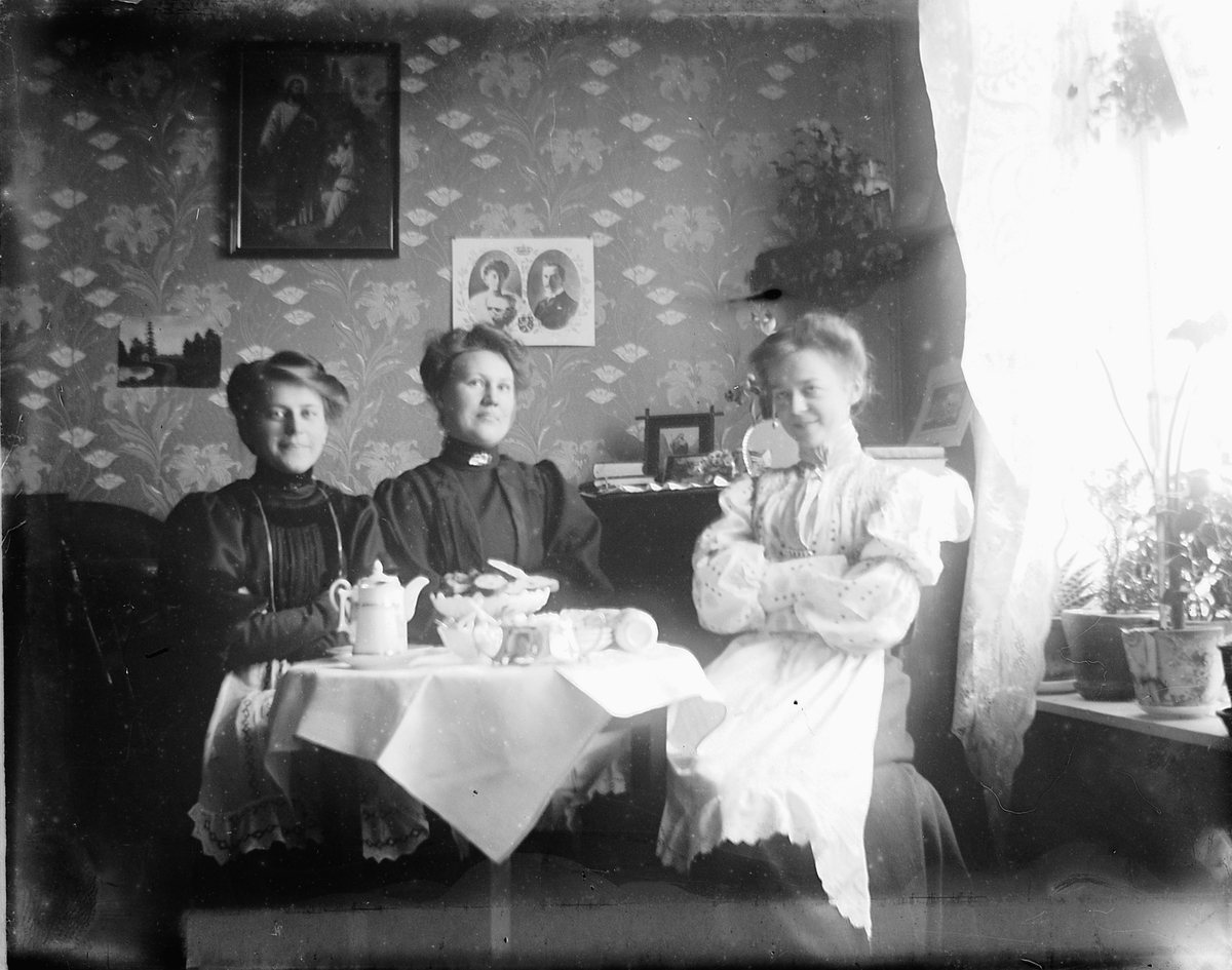 Hamar, Strandgata 15, Interiør, stue. Tre kvinner sitter i en sofa og drikker kaffe. Fra venstre: Louise Johannessen (1887-) gift Finsdahl er datter av bakermester Olaus Johannessen (1856-1915) og Lovise Johannessen (1887-1954), Paula ?, Aagot Johannessen (født Morbech) (1888-1966)