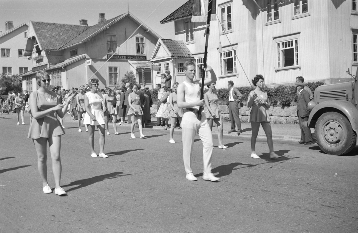 Turnstevne i Moelv i 1959. Turnere marsjerer gjennom Storgata på veg til Idrettsparken. 