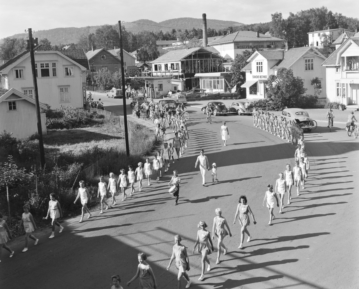 Turnstevne i Moelv i 1959. Turnerer marsjerer gjennom Storgata på veg til Idrettsparken. 