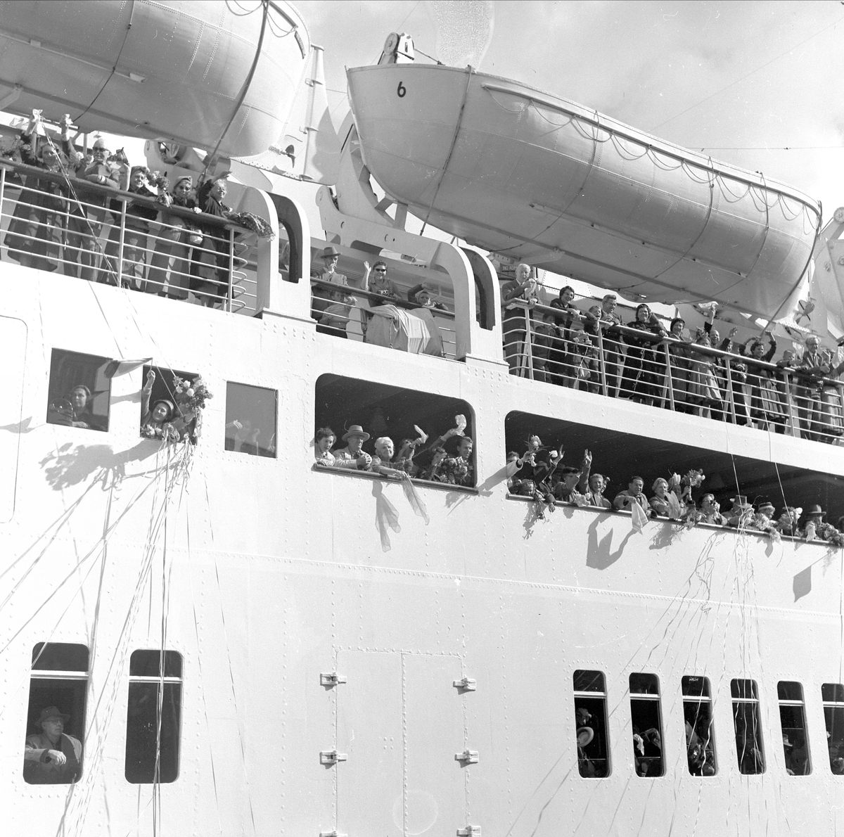 "OSLOFJORD" LEGGER UT FRA KAIA I OSLO. JON REISTAD FRA SKØIEN GÅRD, LØTEN REISTE TIL AMERIKA. . PASSASJERER VINKER FARVEL FRA "AMERIKABÅTEN" 17. SEPTEMBER 1957