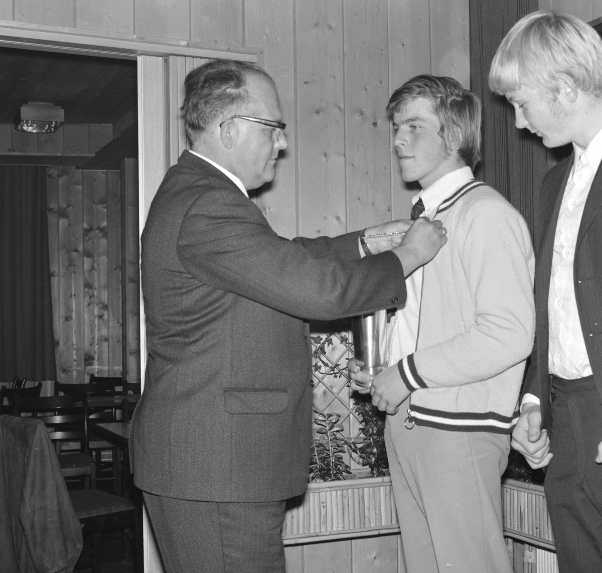 NM Fotball Sveum. Brumunddal. Norgesmesterskapet for junior. 11. 10. 1970. Bankett på Samvirkelagskafeen etter kampen. Fred Roar Hansen får mesterskapsmedaljen av formann i Oplandenee fotballkrets Jarle Johansen. 
