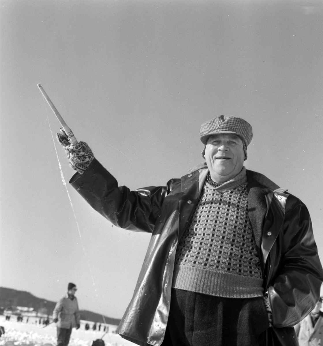 Pilkekonkurranse utenfor Strandsaga i Brumunddal 09. 03. 1958. Fiskekonkurranse på Mjøsisen. Isfiske. ukjent pilker. 
Premier i pilkekonkurransen var bla. en bil, Skoda 1958 modell, motorsykkel, kjøleskap, reiseradio. Se. Na-00293-31 og Na-00293-32 for flere opplysninger. 