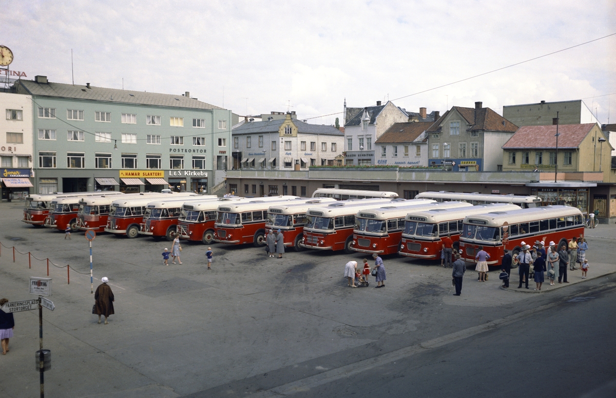 Hamar, Østre Torg, rutebilstasjonen, A/L Hamar og Omland Bilruter, HOB, 14 busser oppstilt på torget, fotoopptak for Vestfold Bil og Karosserifabrikk i Horten, med røde chassis, i 1961 hadde de 48 busser,