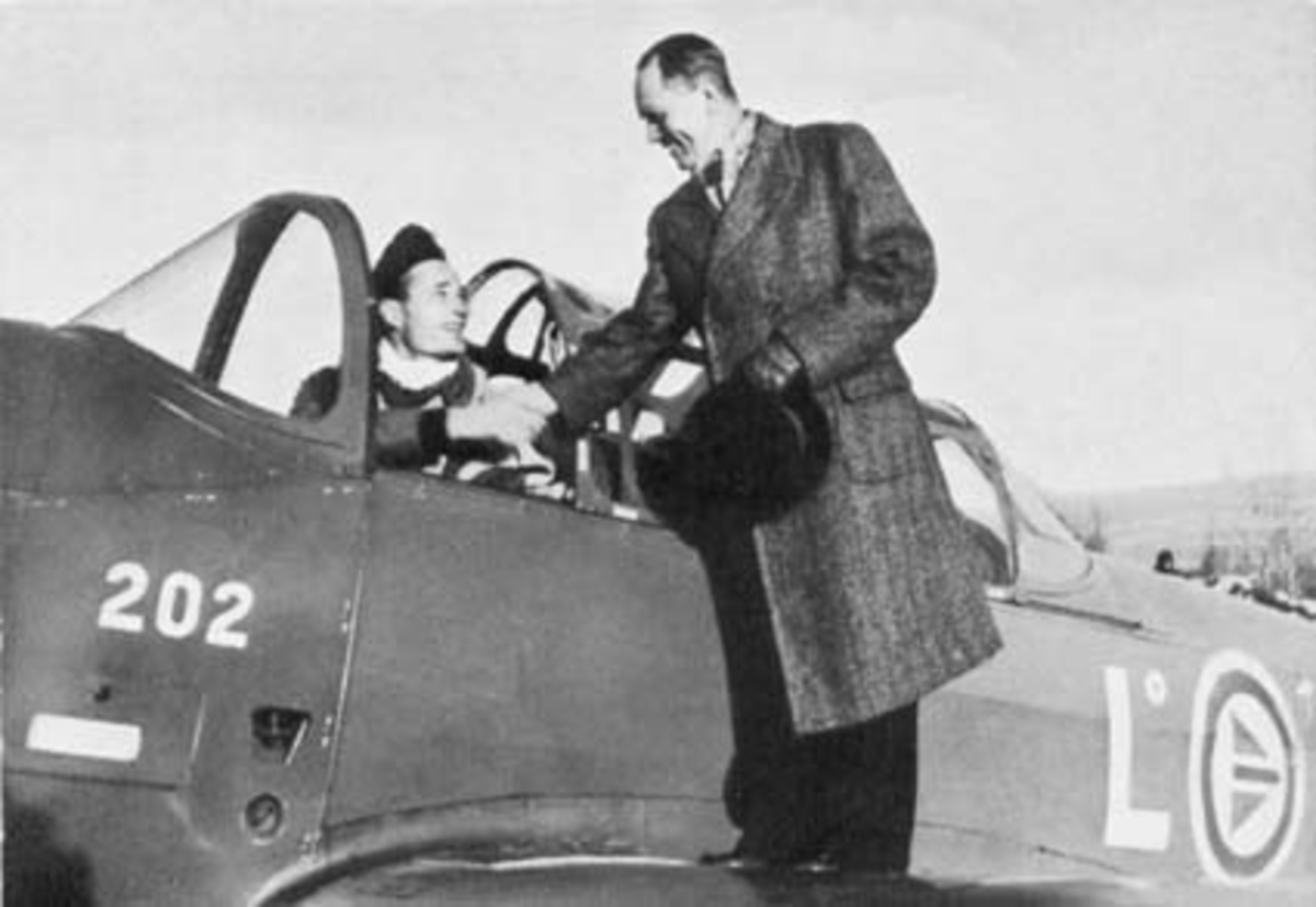Hamar flyplass, Stavsberg, åpningsdagen 17.11.1950. Treningsfly fra Luftforsvarets flyskole av typen Fairchild Cornell. formann i flyplasskomiteen Erling Vold hilser på pilot Emil Erla,