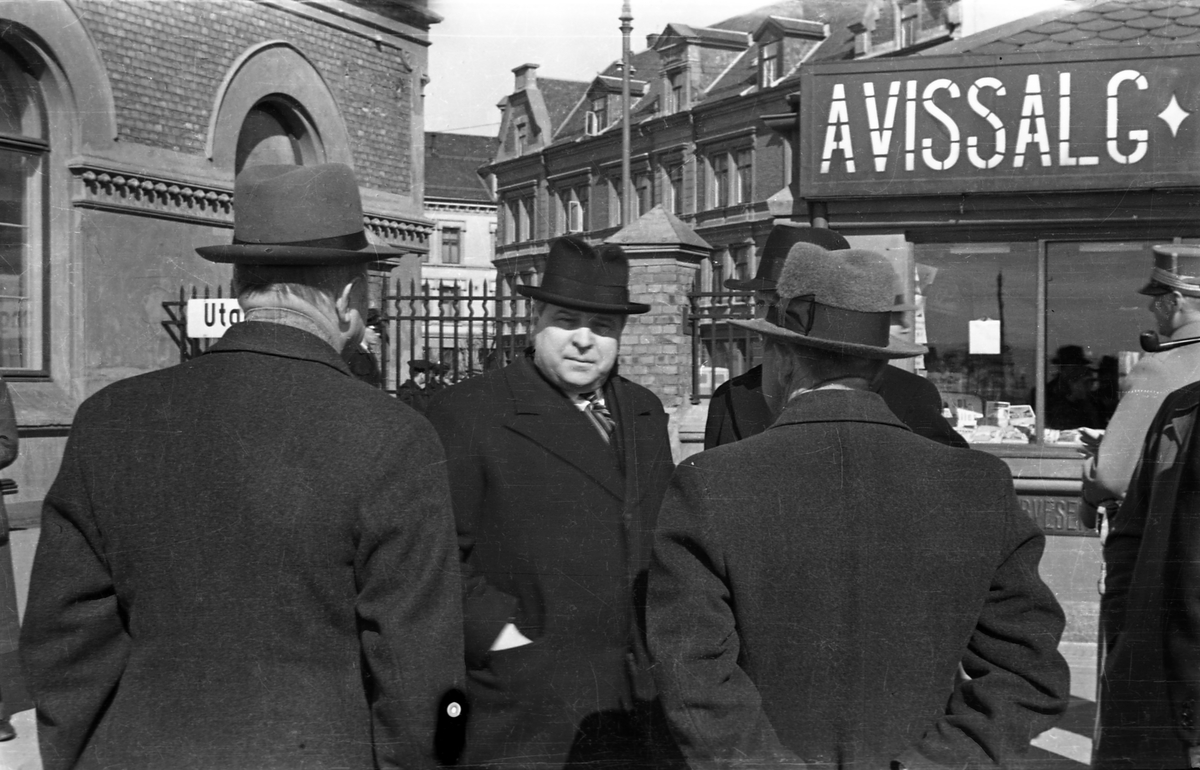 Hamar stasjon, 9. april 1940. Kongefamilien og regjeringen ankommer jernbanestasjonen. I midten stortingspresident Carl Joachim Hambro. (05.01.1885 - 15.12.1964) utenfor Narvesenkiosken,