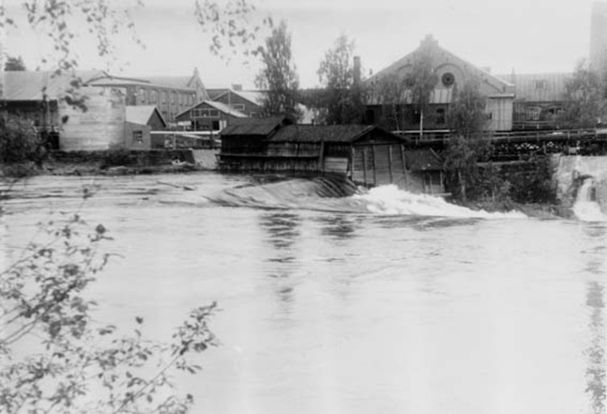 Drammenselvens Papirfabrikker på Modum i Buskerud, fotografert fra øst.  I forgrunnen ses Drammenselva og Geithusfossen.  Fotografiet ble tatt i 1953. 