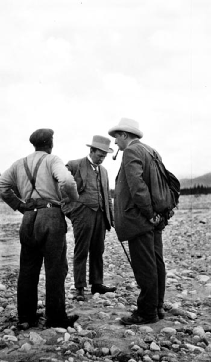 Tømmerfløter Per Øien (i noen sammenhenger også kalt Peder Øien), fløtingsdirektør Wilhelm E. Blakstad og fløtingsinspektør Odd Daae ved Osas utløp 28/6-1916. Fotografiet er antakelig tatt i forbindelse med en befaring etter at dammen brast, noe som utløste en flom som skapte store ødeleggelser på bruer, bygninger og andre verdier langs vassdraget - fra Osensjøen og ned til Rena. 

Per Øien står arbeidskledd med ryggen til fotografen.  Han har belte med tollekniv på ryggen og bukseseler over ei lys trøye.  På hodet har han sixpencelue.  Til høyre står Odd Daae, som var fløtingsinspektør for Christiania Tømmerdirektion (Glomma Fellesfløtingsforening) med bopæl på Rena.  Han har ryggsekk, ei litt krøllete og dratt jakke, tobakkspipe i munnen og en lys hatt på hodet.  Mellom dem står Wilhelm E. Blakstad.  Han er iført dress med vest, kvit skjorte, slips, lys hatt og spaserstokk. 

Per Øien og arbeidskameraten Per Vangli ble helter under Osfallskatastrofen.  Da det ble kjent at kraftsverksmaskinisten og hans gamle mor satt hjelpeløse i et hus som befant seg midt i det nye løpet elva hadde tatt, fikk de en hest til å trekke en fløterbåt ned til ulykkesstedet.  Med denne båten satte de to ut i strømkavet, og fikk manøvrert seg ut til den sammenraste boligen, der det viste seg at den eldre kvinna lå fastklemt under en bjelke.  Hun døde dessverre mens de to fløterne forsøkte å frigjøre henne ved å hogge over bjelken.  Maskinisten greidde de imidlertid å få satt trygt over til den søndre elvebredden.  For denne heltedåden, som ble utført med stor fare for egne liv, mottok Per Øien og Per Vangli både kongens fortjenstemedalje i gull og Carnegiemedaljen.