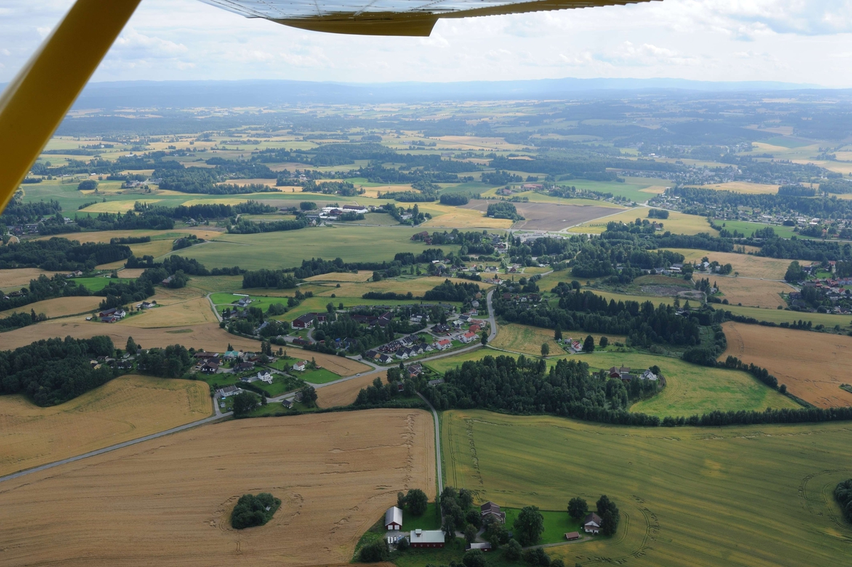 Flyfoto. 
Luftfoto utført i forbindelse med Vangsboka. Gårder i Vang, samt noe Hamar by fra lufta. 