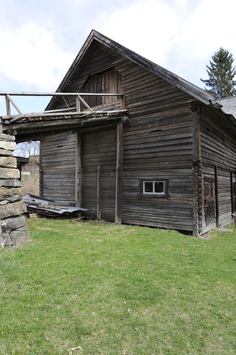 Låve med to fløyer i vinkel, laftet: Bygningen har saltak tekket med flis. Kjøringa går gjennom hele bygningen og har sin begynnelse over stallen i nord. Dette er et tidlig eksempel på en enhetslåve der mange funksjoner er samlet under et tak. Stallen har innredning for fem hester med krybbe og foringsgang. På langsiden inn mot tunet er det oppført et hus for hestevandring. Det har pyramideformet tak som hviler på stolper.