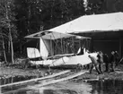 Flygplan Donnet-Lévêque på marken vid strandkant. Tekniker i arbete med flygplanet.