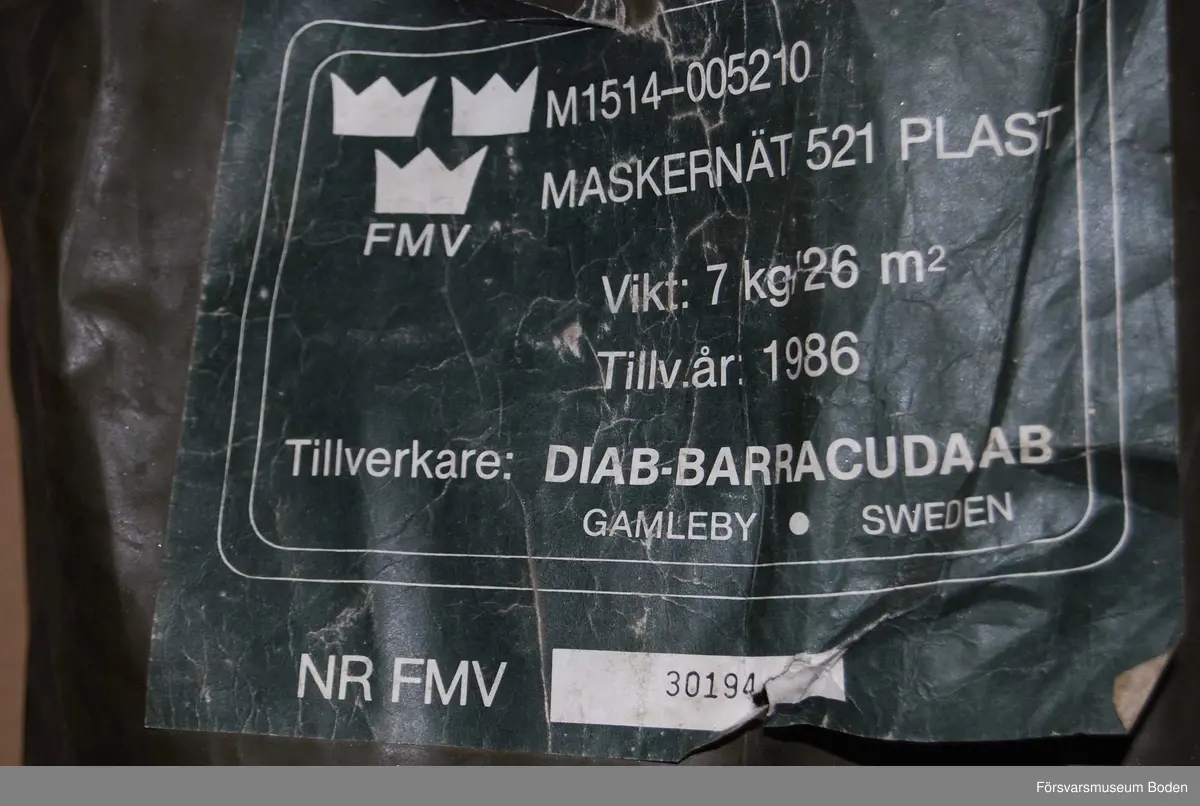 Maskeringsnät i säck av plastväv, materielnummer M1514-005210. Tillverkat 1986 av Diab-Barracuda, Gamleby. Nr 30194.