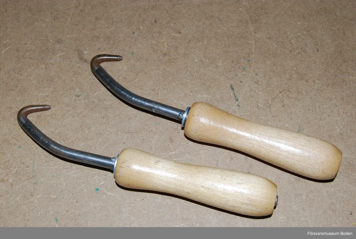 Två krokar med vridbara handtag av trä. Civilförsvarsmateriel från Televerket.