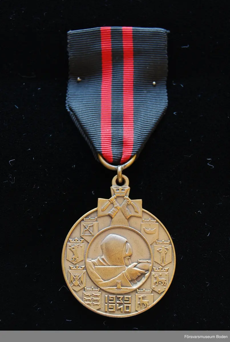 Tavla med uppsatta medaljer på svart sammet. Har tillhört Karl Hjalmar Lindskog, finlandsfrivillig 1939-1940. Från vänster på bilden:
1. Lapplands kors, stort, brons. Urkund finns i pärm under FMB.002361.
2. Lapplands kors, litet, brons.
3. Vinterkrigets minnesmedalj, brons.
4. Svenska frivilligkorset, litet, järn.
5. Svenska frivilligkorset, stort, järn. Urkund finns i pärm under FMB.002361.