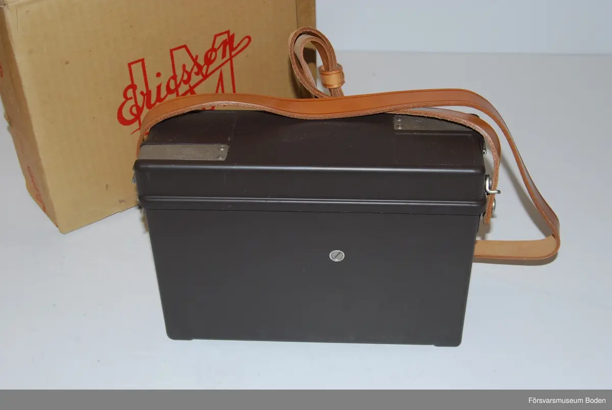 Ny i öppnad kartong. Telefonapparat m/1937 utan LB/CB-omkopplare och klyka. Tillverkad under vecka 50 1963 enligt stämplar på chassi och emballage. Inget synligt serienummer i övrigt.