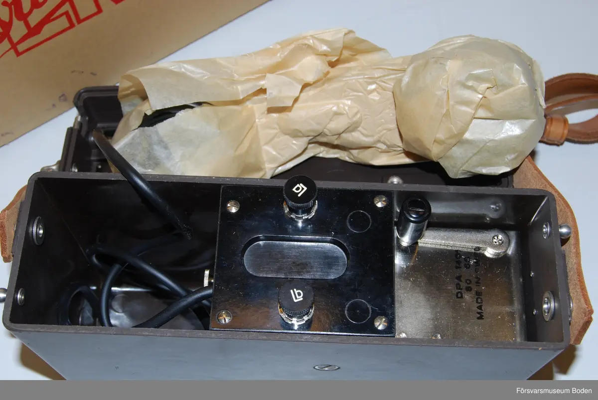 Ny i öppnad kartong. Telefonapparat m/1937 utan LB/CB-omkopplare och klyka. Tillverkad under vecka 50 1963 enligt stämplar på chassi och emballage. Inget synligt serienummer i övrigt.