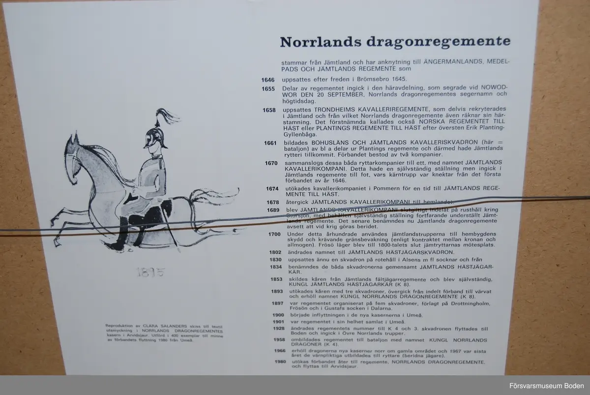 Reproduktion av Clara Salanders skiss till textil utsmyckning i Norrlands dragonregementes kasern i Arvidsjaur. Utförd i 400 exemplar till minne av förbandets flytt från Umeå 1980. Träram 154 x 31 cm med matt täckglas av plast.. Inramad hos Stadins konst- och ramaffär, Boden.