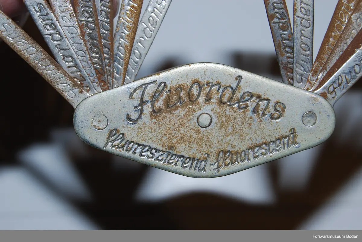 13 olika tänder av porslin eller liknande material monterade på metalltungor. Färgerna är numrerade 81-90 och 92-94. Varumärke "Fluordens", tillverkade i Tyskland av C.M. Hutschenreuther A-G. Troligen tillverkade före andra världskriget.