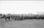 Regementsstaben (närmast kameran) uppställd på fältet söder kasern för korum vid kamratföreningens besök 1931. I bildens högra kant ryttmästare Rolf Örn på 