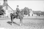 Livhusar i uniform m/1895 (m/ä) med tilldelad stamhäst på kaserngården söder om skvadronstallarna