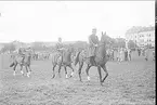 Regementskapplöpningarna 1928 på fältet söder K 3 kasern. Officersjaktloppets deltagare med mastern i täten paraderar för domaren.