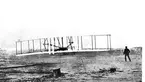 Den första egentliga motorflygningen av Orville Wright (liggandes på undervingen. 17/12 1903.