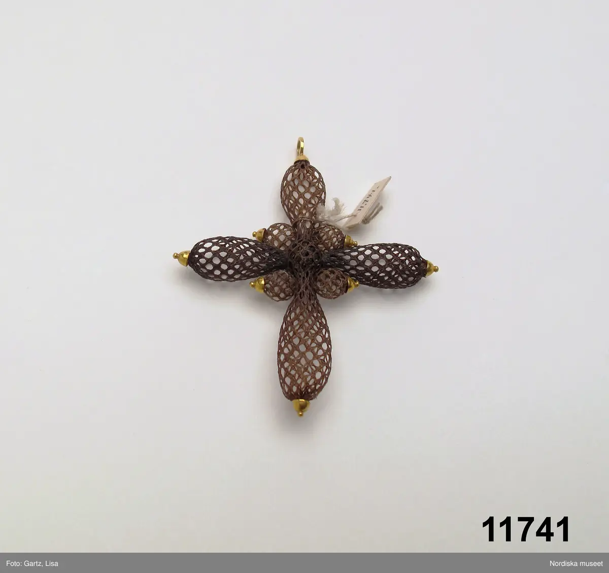 

Huvudliggaren:
"Kors af hår. [föremålet består av endast en del. Litteran berättar bara vilkas hår som ingår i smycket. På katalogkortet visar litteran vems hår som använts till vilka delar av smycket]
a) Vieselgrens hår. (Peter)
b) Scotts hår. (George)
c) Barids hår. (Robert)
[handskrivet tillägg:] alla tre nykterhetskämpar; träffades 1840 i prästgård här i Sverige; korsets hår trol från detta tillfälle /1979-11-28 MP.
G ss 11.738 [=af rådman J. O. Pira och fru A. M. E. Pira född Saefström. ] 7/8 1876."