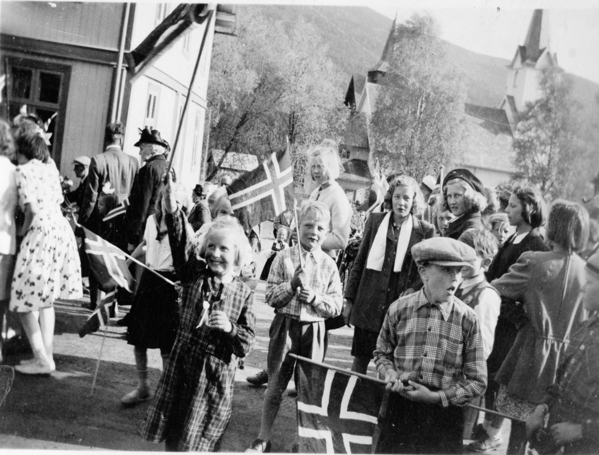 I midten frå v.Solveig Breibrenna og Sander Tufte med flagg ved Torpo Kyrkje.