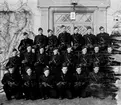 Grupporträtt av elever vid korpralskolan på F 2, 1944. Flygplansmekaniker ur 2:a plutonen utrustade med vapen vid trappa.