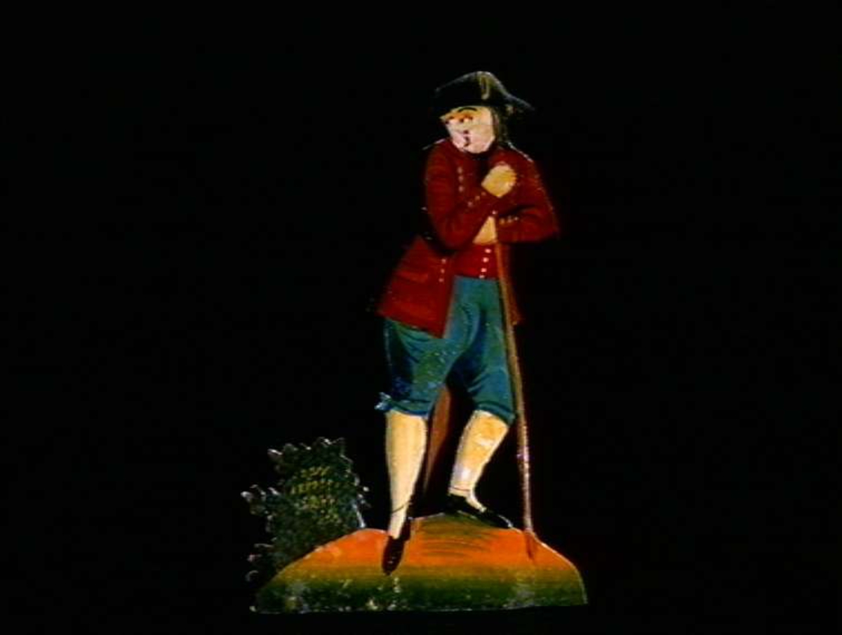 Figurer i papir med trefot i form av husfasader, tær, dyr og mennesker. Tilhørende eske.