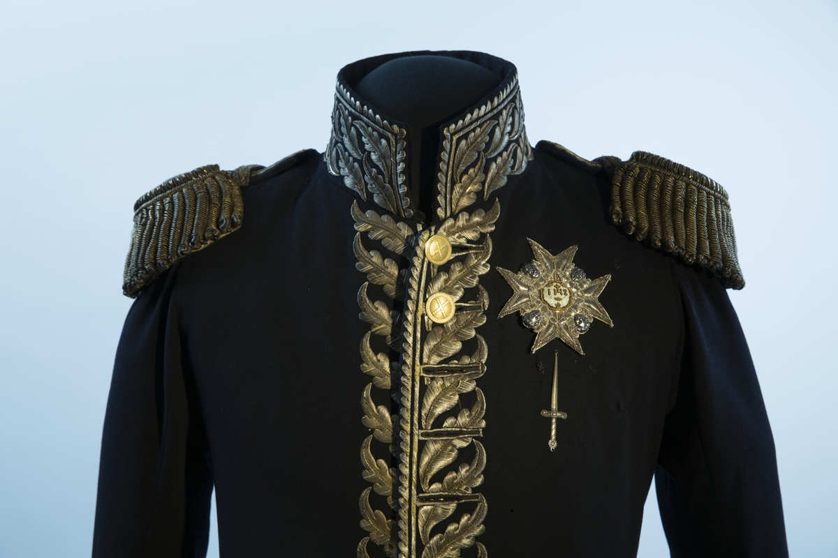 Mørkblå frakk med dekor av metallbroderi.