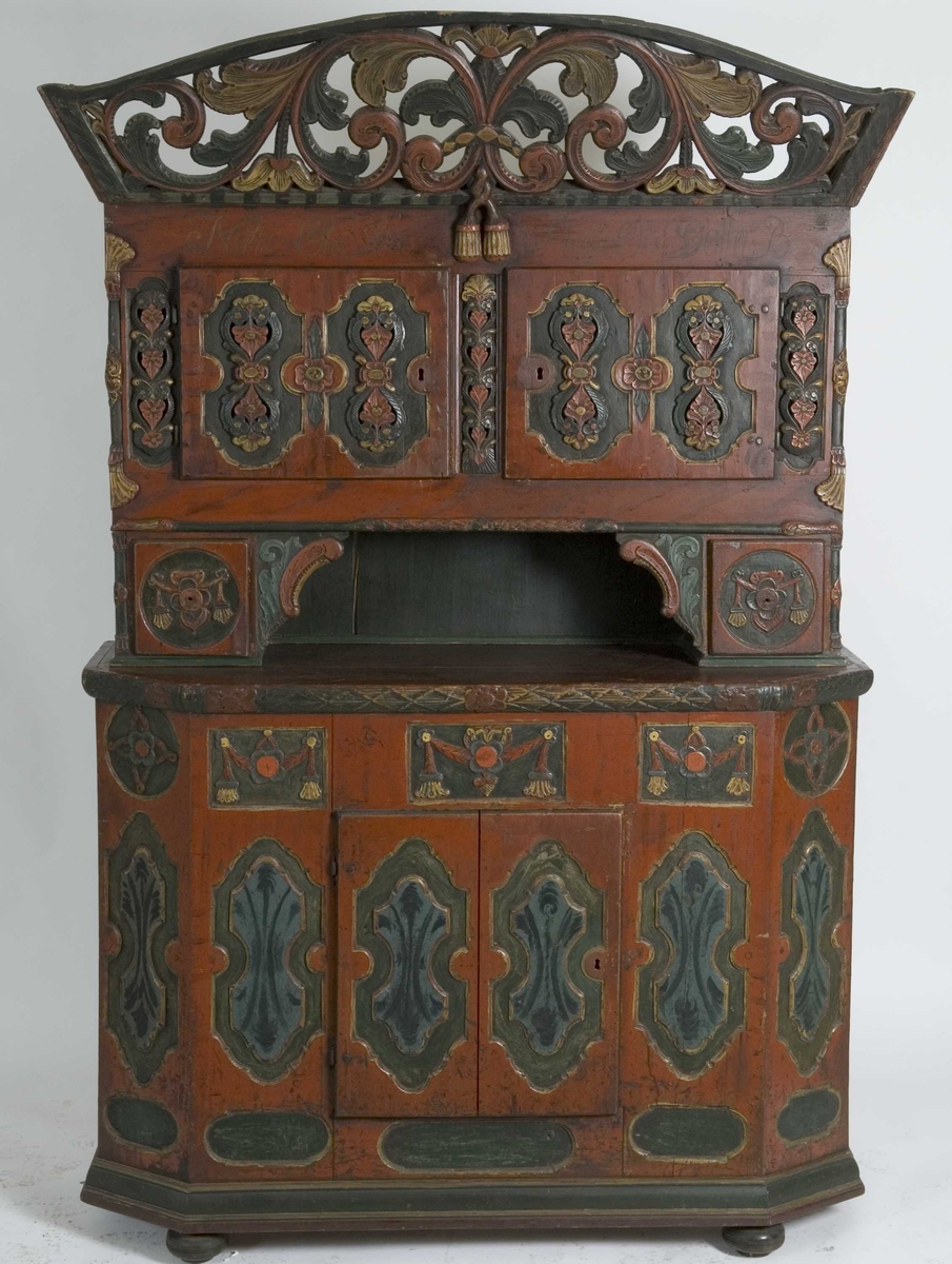 Framskap på fire dreide ben. Dekorert med marmorering, utskårne klassisistiske motiv og krone med gjennombrutt akantusranke.