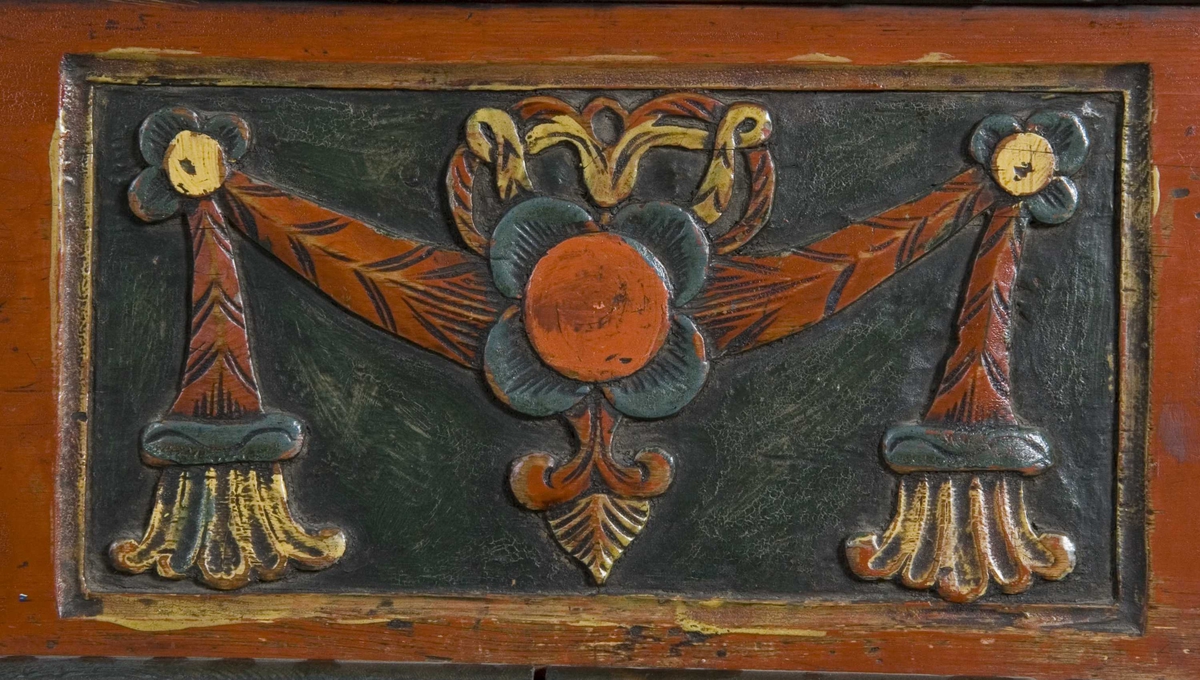 Framskap på fire dreide ben. Dekorert med marmorering, utskårne klassisistiske motiv og krone med gjennombrutt akantusranke.