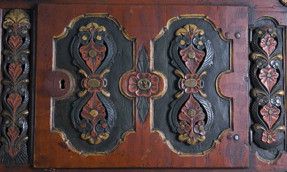 Framskap på fire dreide ben. Dekorert med marmorering, utskårne klassisistiske motiv og krone med gjennombrutt akantusranke.