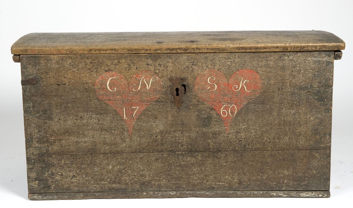 Kiste med buet lokk. Forsiden malt to røde hjerter med  innskrift.