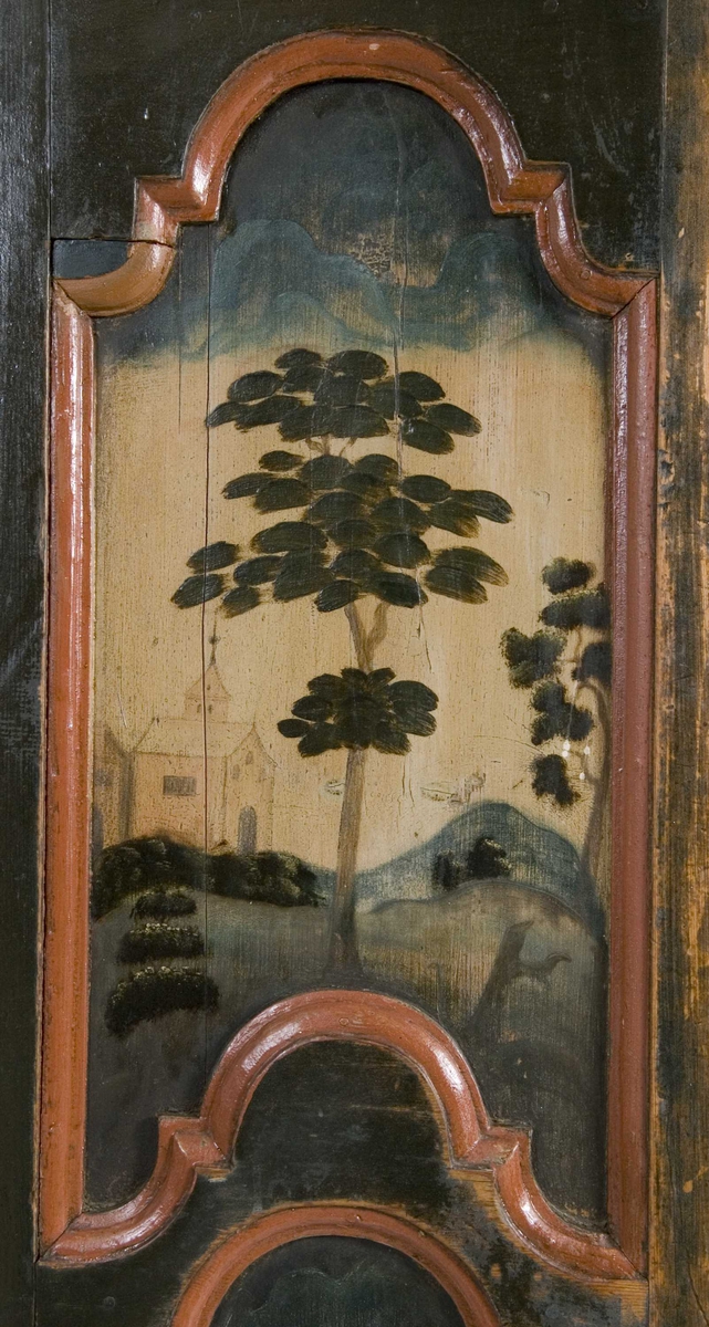 Flatskap med doble dører og klaff i overkant, hengslet på undersiden. Dekormalt med landskapsmotiver i feltene.