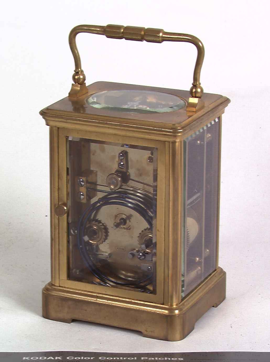 Reiseur (carriage clock) i brennforgylt messingkasse med fasettslipte glass.