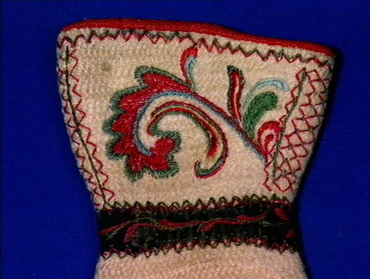 Hvite votter i nålebinding med dekor ab broderi og applikasjon.