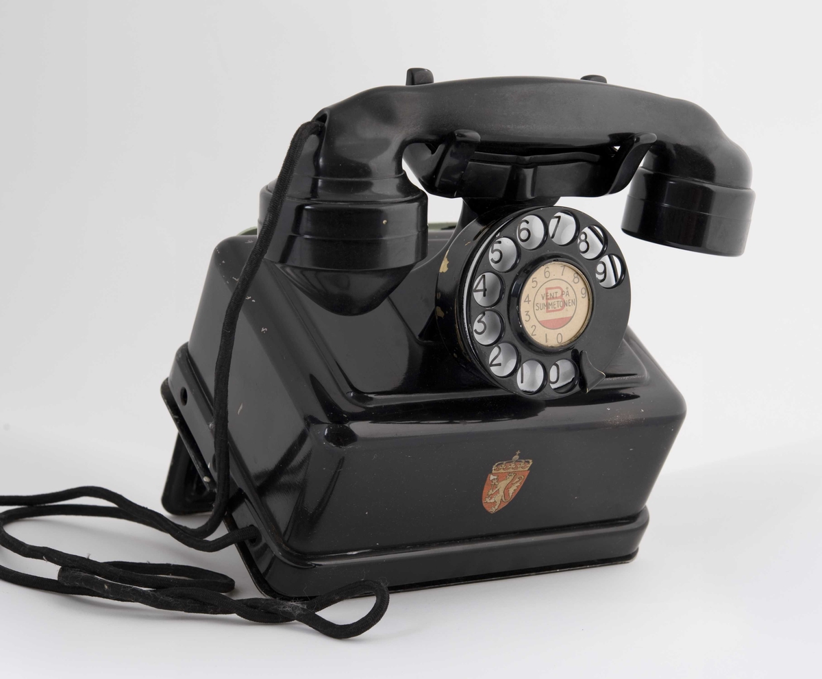 Telefon montert på stativ til å skru på veggen.