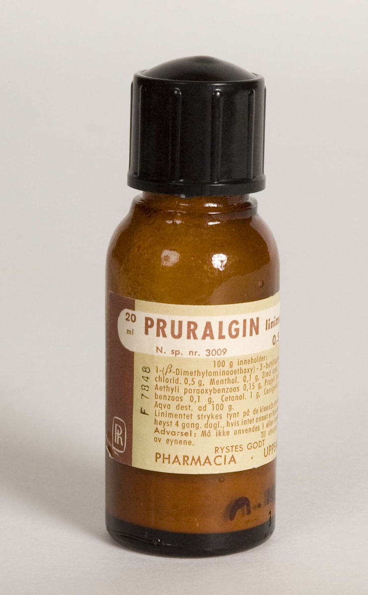 Liniment i originalpakning. Glassflaske med skrukork, brun og grønn pålimt etikett.