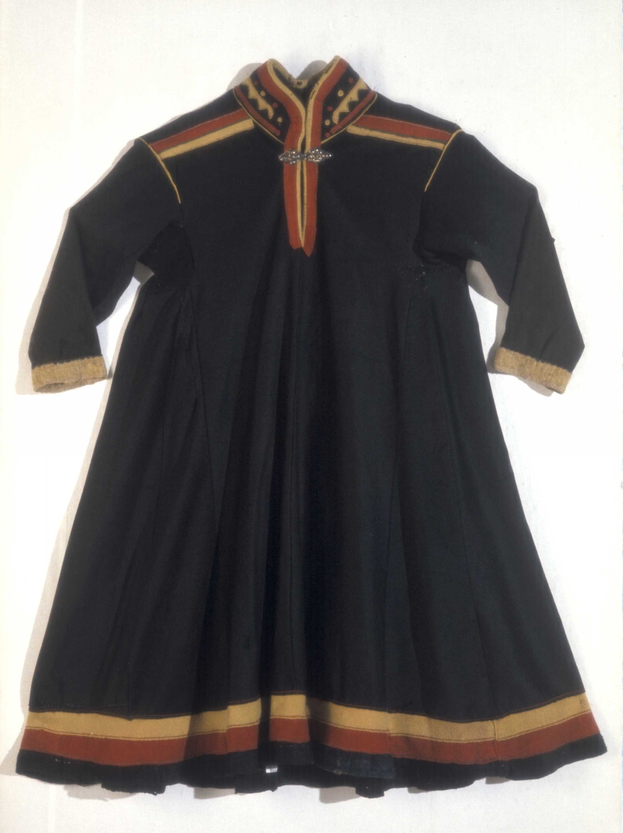 Svart kofte av klede med dekor av gult, rødt og beige klede.