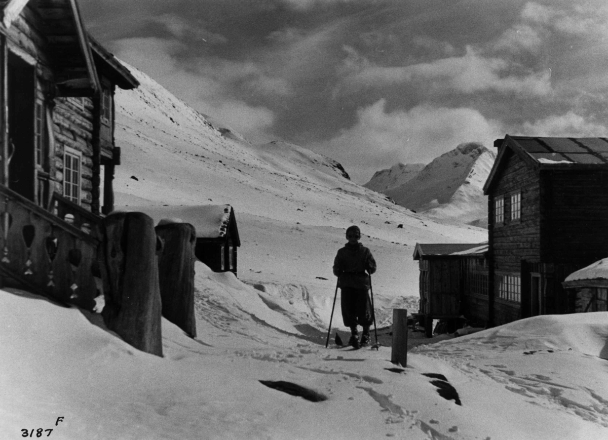 Skiløper ved Spiterstulen i Visdalen i Jotunheimen med snødekte fjell.