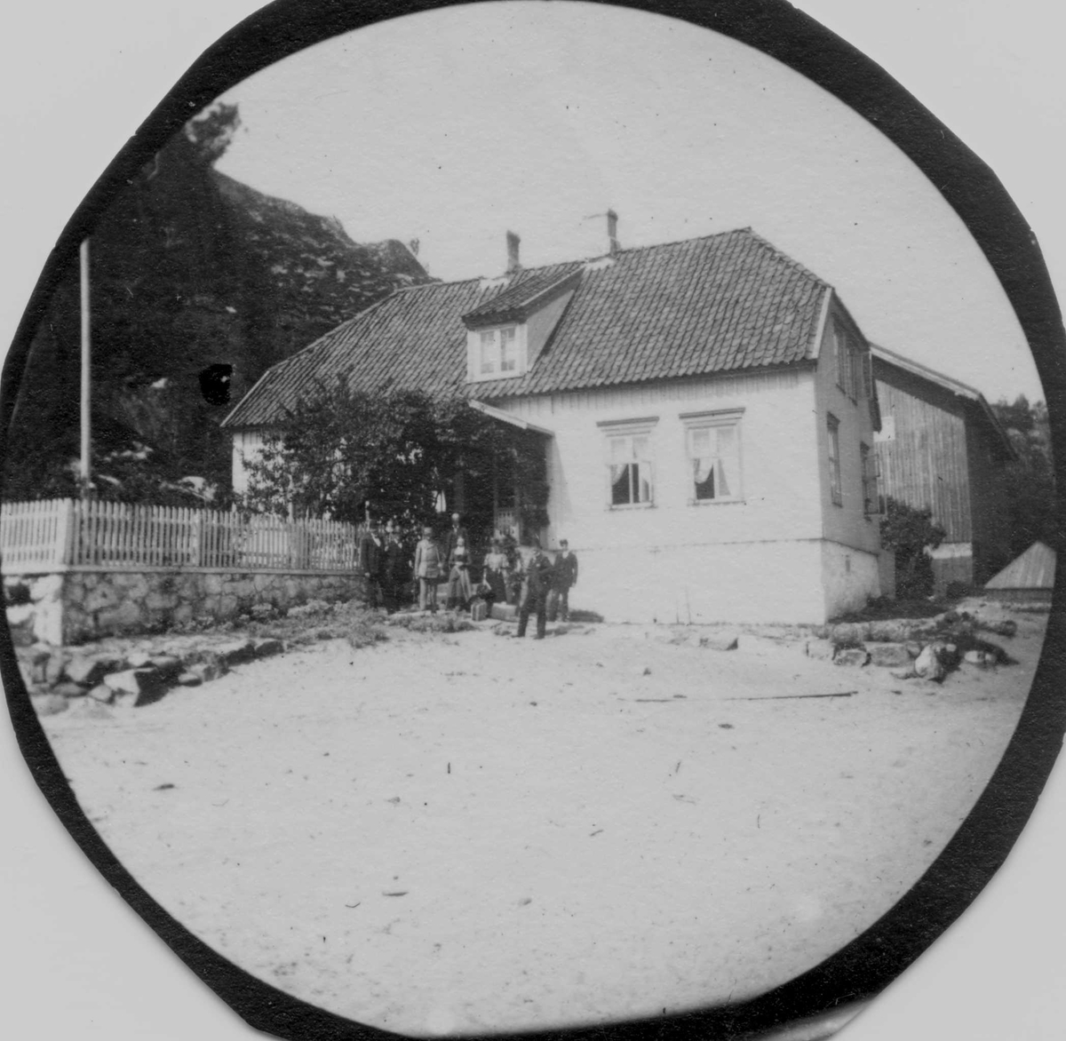Fra ekskursjon med professor Blytt til Kjerringvik, Tjølling, Vestfold. Gruppe foran hus og hagegjerde.