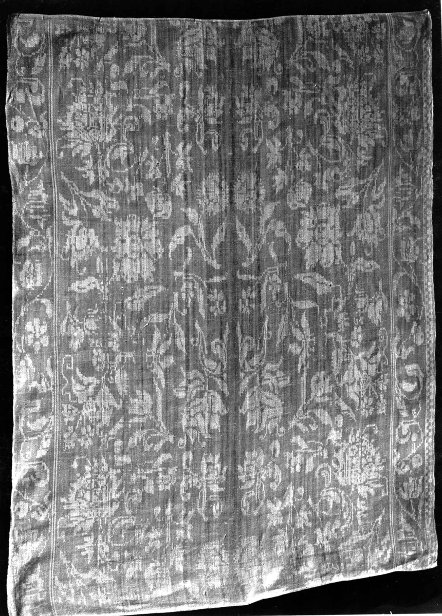 Hvit damaskserviett med mønster av strøblomster, rankebord. Antagelig fra Tyskland slutten av 1700-tallet.