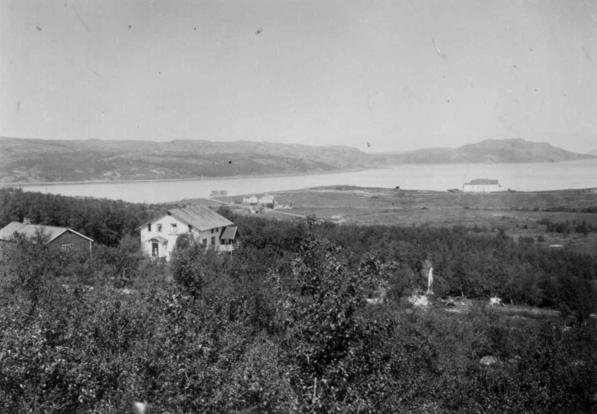 Kirkenes kirke, Sør-Varanger, Finnmark, med prestegården, 1899. Nærmest ligger legeboligen for familien Wessel og lengst borte t. v. for kirken handelsmann Figenskous bolig.